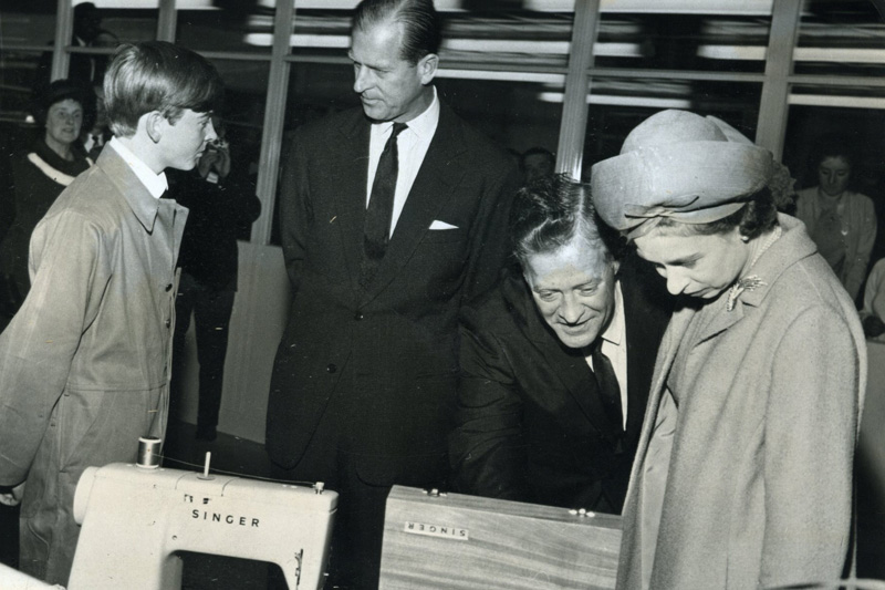 image of Queen Elizabeth II receiving a sewing machine from Singer during her visit to the factory in 1965.