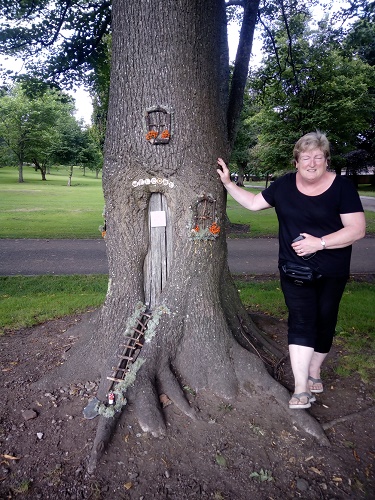image of Volunteer Anne in front of carved tree