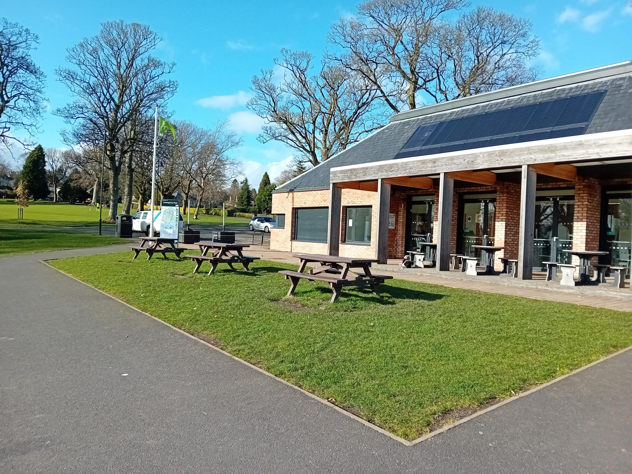 External side view with picnic benches in front of Pavilion Cafe Entrance 