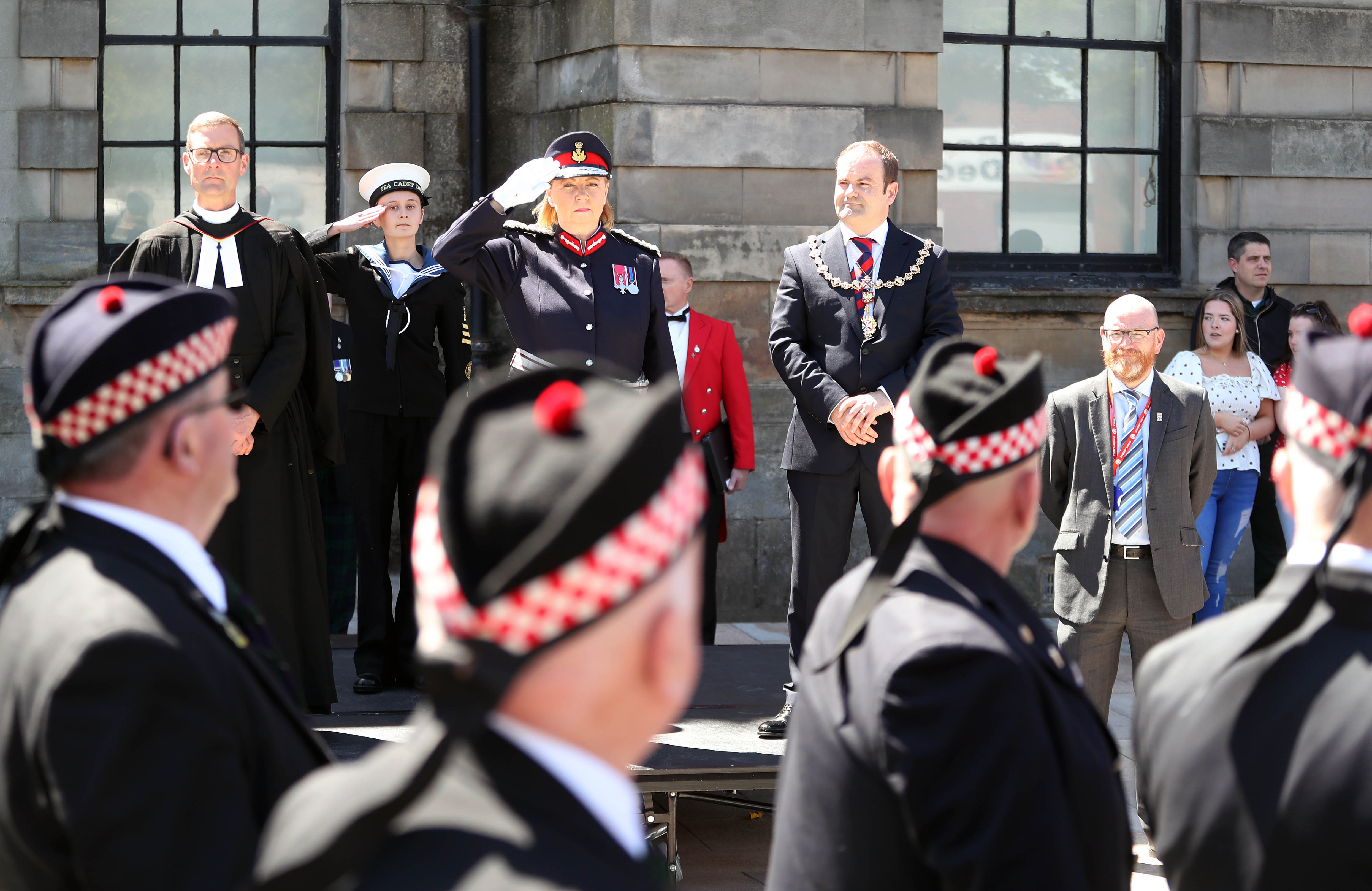 Salute during armed forces day parade with armed forces personnel marching past Clydebank Town Hall